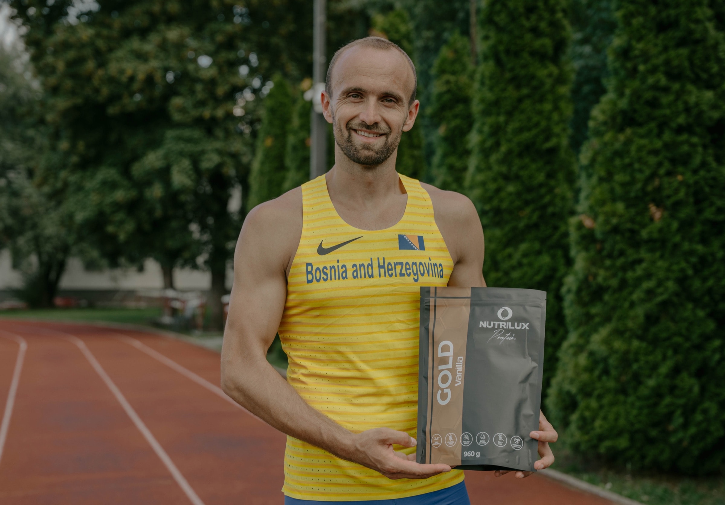 Amel Tuka drži Nutrilux GOLD protein na atletskoj stazi